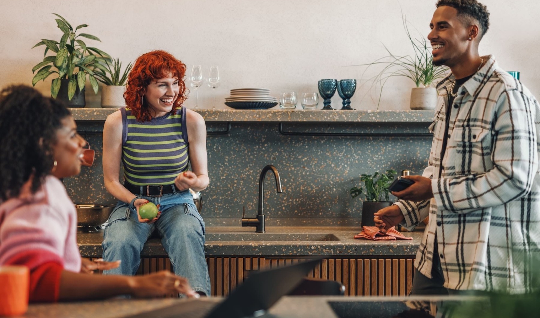 a few people laughing in a kitchen